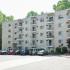 Residential buildings with balconies and a parking lot view at Gayley Park apartments for rent