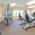 Fitness center at Summit Trace Apartments in Langhorne, PA has weight machines and stationary bicycles.