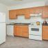 Model kitchen with tiled floors, wooden cabinets and modern appliances at Summit Trace Apartments in Langhorne, PA.
