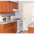 Kitchen with white appliances and storage closet in Middle River Townhomes for rent