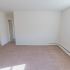 Living room with baseboard heating and a window letting in light at Evergreen Club apartments for rent