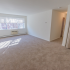 Large living room with a sizable window, coat closet, and plush carpeting at Evergreen Club apartments for rent in Broomall, PA