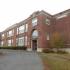 Homeroom Lofts Apartments, exterior, large red brick building, large driveway, trees, grass