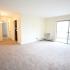 Carpeted living room with large sliding door at The Commons at Fallsington apartments for rent in Morrisville, PA